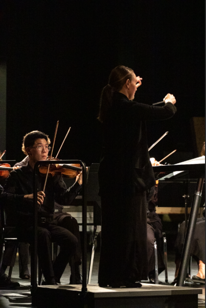 Directer Sarah Heuermann stands in front of the orchestra as they perform. Heuermann conducted the concert on Oct. 8 in the PAC.